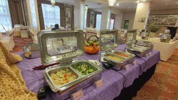 A buffet table with various food containers, a pumpkin decoration, and a sign indicating 'Asian Cuisine.'