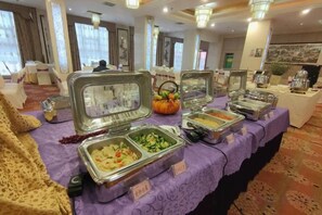 A buffet table with various food containers, a pumpkin decoration, and a sign indicating 'Asian Cuisine.' - Tianma Hotel (Wuwei)
