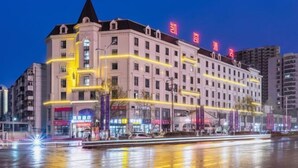 A multi-story hotel with a prominent corner tower, large windows, and a reflective facade.