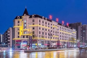 Un hotel a più piani con una torre imponente, ampie finestre e una facciata riflettente.