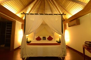 A four-poster canopy bed with a wooden ceiling and two bedside lamps. - One Myanmar Resort Ngapali (Ngapali)