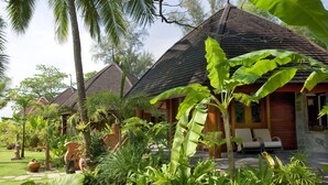 A resort with multiple bungalow-style buildings, lush tropical gardens, and a well-maintained lawn. - One Myanmar Resort Ngapali (Ngapali)