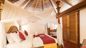 A bed with a canopy, wooden headboard, and a red and yellow bedspread. - One Myanmar Resort Ngapali (Ngapali)