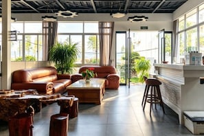 A spacious lobby with a leather sofa, a coffee table, and a bar area. - Hersy Vista · Hesi 270° Panoramic Erhai-Cangshan View Boutique Stay (Dali City)