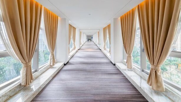 A corridor with large windows and curtains, leading to a room with a wooden floor. - Chengtou Gangwan Hotel (Zunyi)