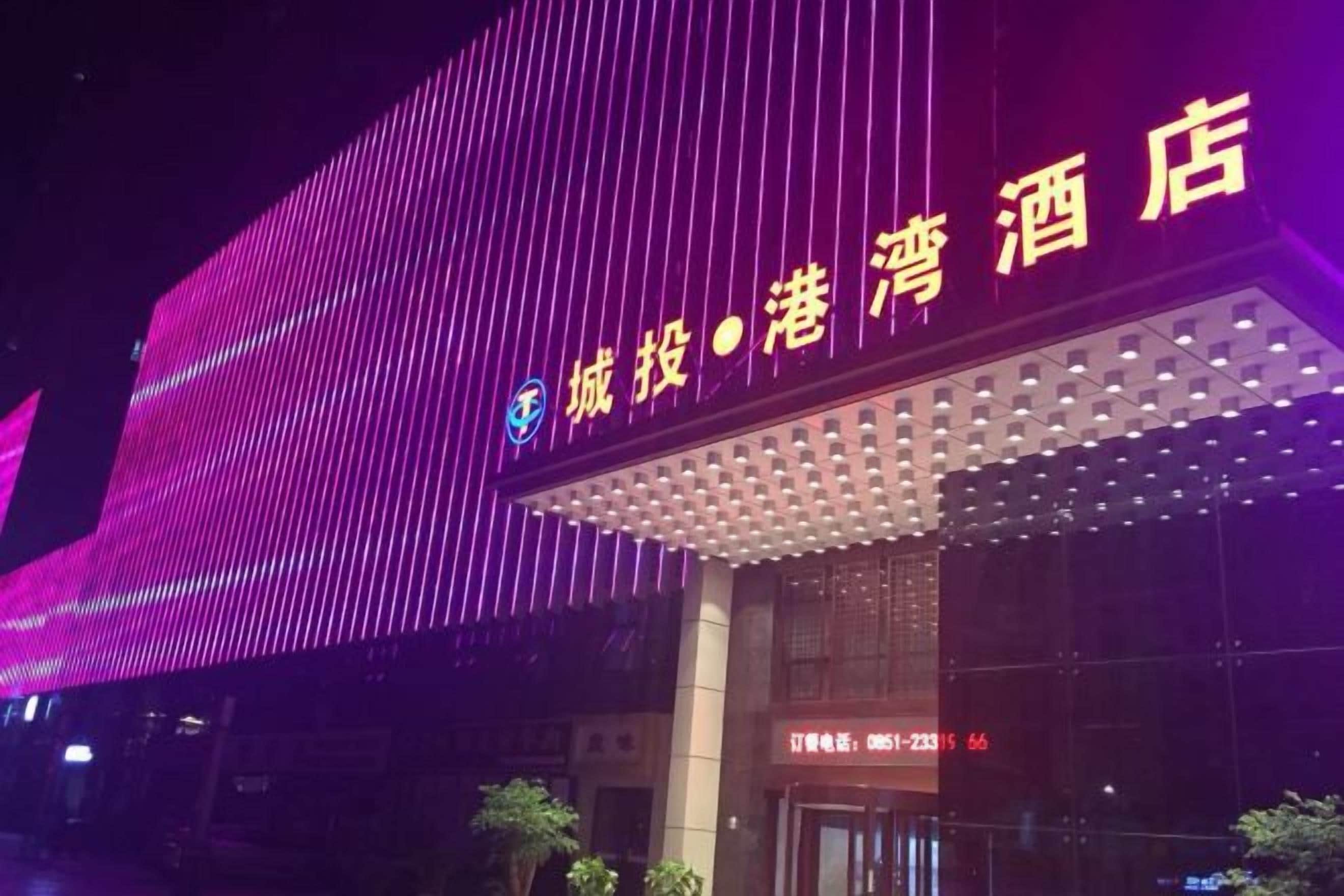 A hotel with a prominent entrance and illuminated signage.