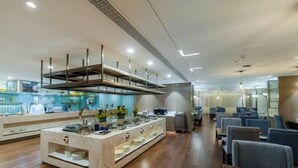 A modern restaurant with a central island, seating area, and a kitchen in the background. - Chengtou Gangwan Hotel (Zunyi)