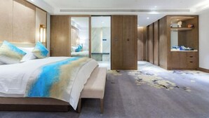A modern hotel room with a large bed, a walk-in closet, and a bathroom with a mirror and shelves. - Chengtou Gangwan Hotel (Zunyi)