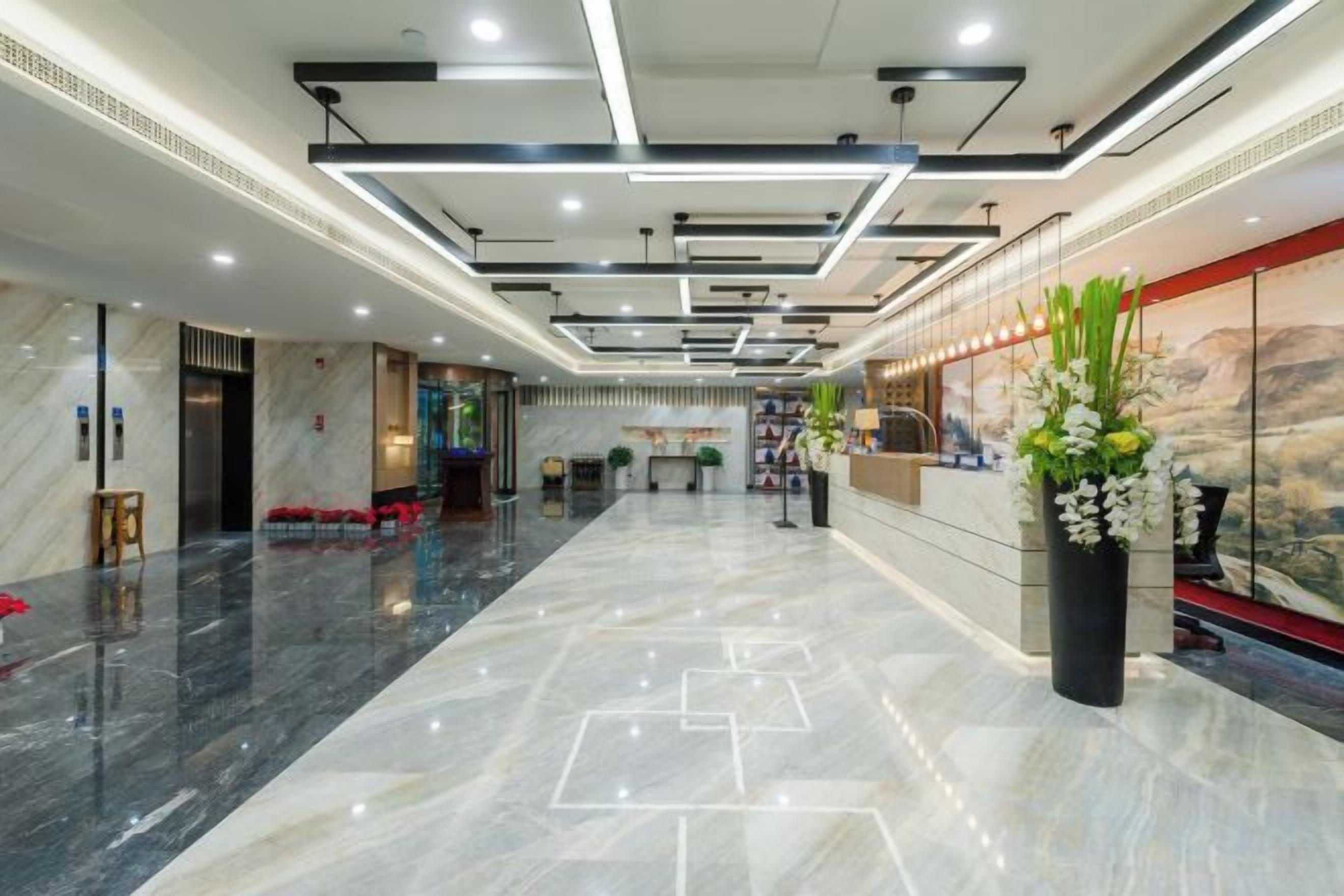 A hotel lobby with a marble floor, a reception desk, and a large window with a view.