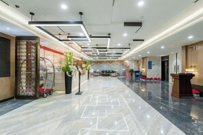 A hotel lobby with a marble floor, a reception desk, and a seating area. - Chengtou Gangwan Hotel (Zunyi)