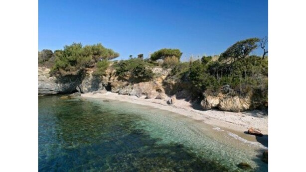 A coastal beach with clear water, rocky cliffs, and sparse vegetation. - T2 quiet, swimming pool, beach 400 m, terrace not overlooked (Six-Fours-les-Plages)