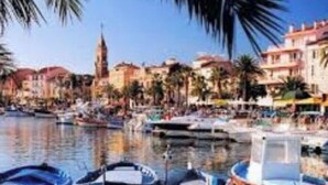 A marina with boats docked, a clear sky, and buildings with red roofs in the background. - T2 quiet, swimming pool, beach 400 m, terrace not overlooked (Six-Fours-les-Plages)