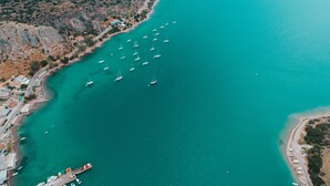 An aerial view of a coastal area with a marina, boats, and buildings along the shore. - Vivari Acta (Nafplio)