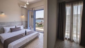 A bedroom with a bed, bedside table, and a view of the outside. - Vivari Acta (Nafplio)