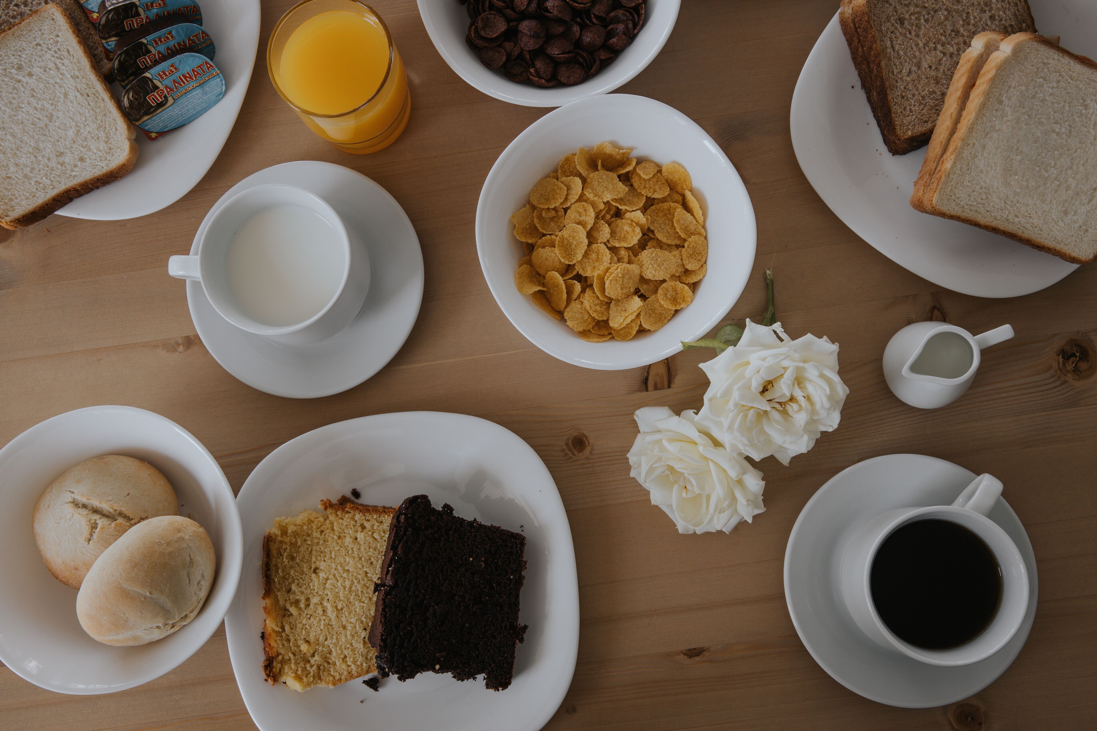 Un desayuno con diversas opciones de comida y bebidas sobre una mesa de madera.