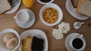 Un desayuno con diversas opciones de comida y bebidas sobre una mesa de madera.