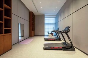 A modern gym with treadmills, a stationary bike, and a yoga mat. - Boxiyueli Hotel (Wuxi Yuantouzhu Scenic Area) (Wuxi)