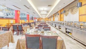 A spacious buffet area with multiple tables and chairs, a long counter with food display cases, and a high ceiling with circular light fixtures. - Gao Qing Ying Bin Hotel（Laocheng Craftsmen Museum） (Gaoqing)