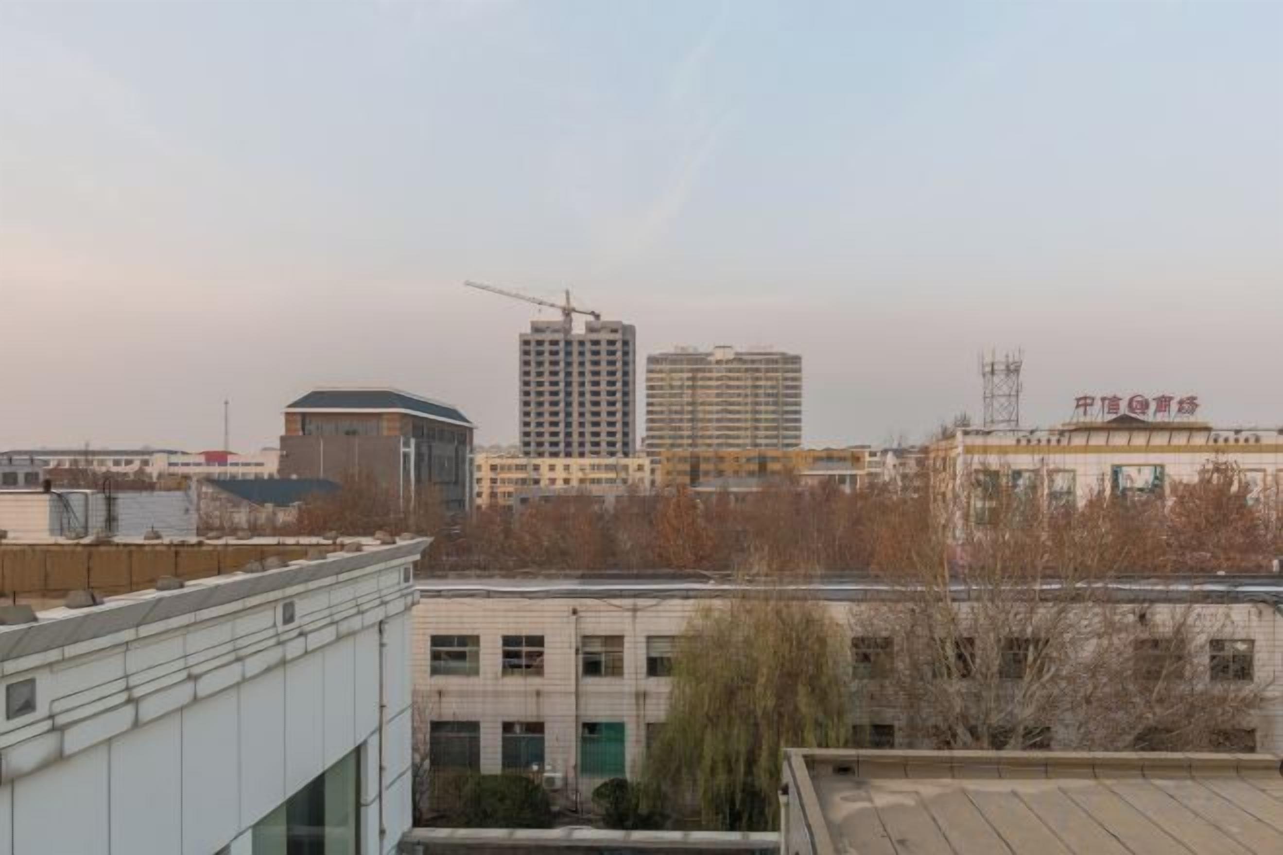 Paisagem urbana com edifícios, incluindo um canteiro de obras com uma grua.