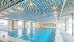 An indoor swimming pool with a grid-patterned ceiling and tiled walls. - Gao Qing Ying Bin Hotel（Laocheng Craftsmen Museum） (Gaoqing)