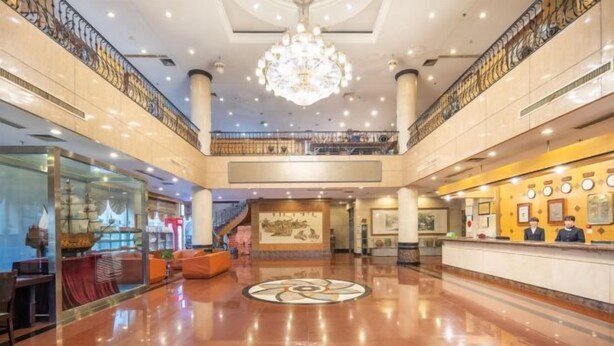 A spacious lobby with a central chandelier, a reception desk, and a staircase leading to an upper level. - Gao Qing Ying Bin Hotel（Laocheng Craftsmen Museum） (Gaoqing)