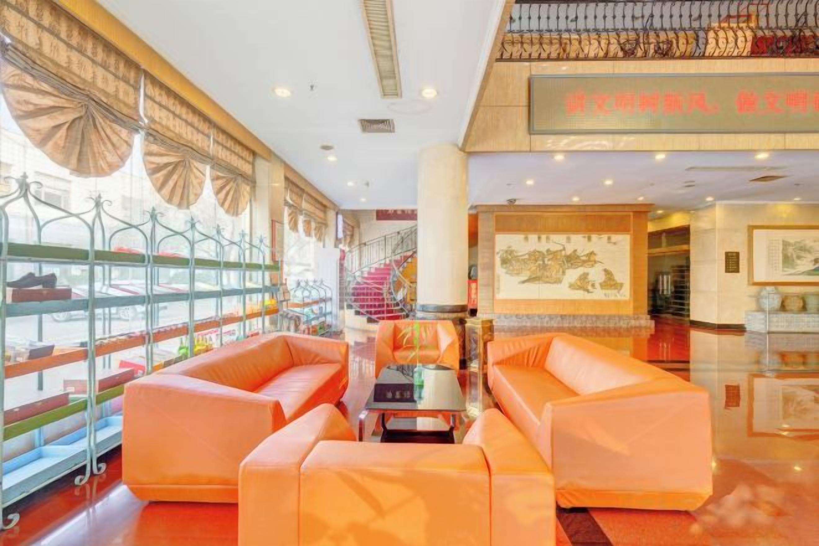 Un vestíbulo de hotel con asientos, una escalera y obras de arte en las paredes.