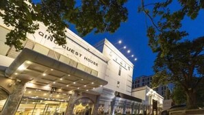 A modern hotel with a prominent "QING GUEST HOUSE" sign, featuring a large glass entrance and a covered outdoor area. - Gao Qing Ying Bin Hotel（Laocheng Craftsmen Museum） (Gaoqing)