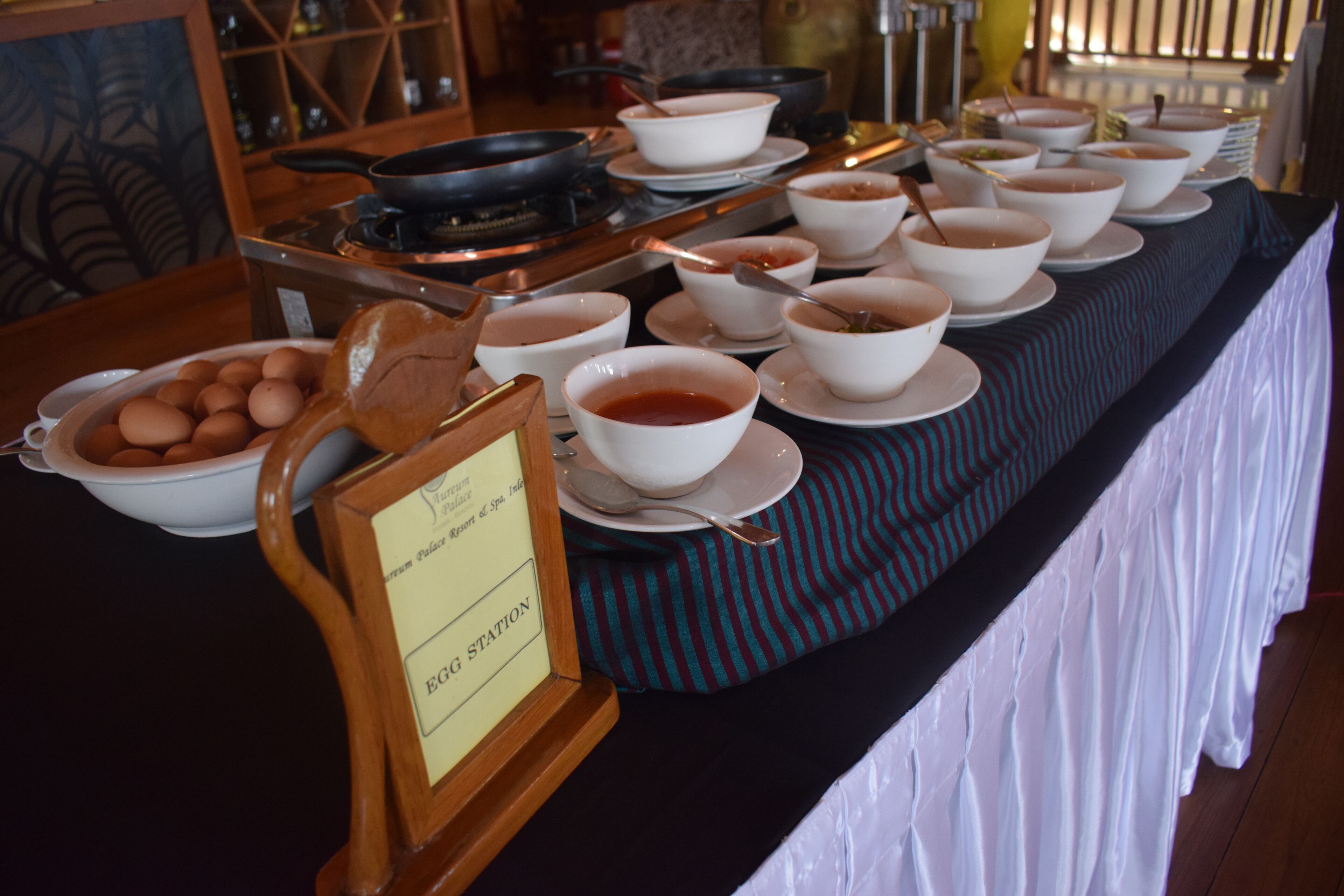 A buffet table with various dishes and a sign labeled "EGG STATION".
