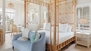 A bedroom with a four-poster bed, a blue sofa, and a large window.