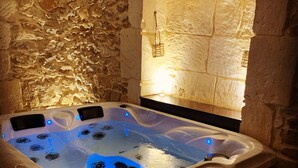 A hot tub with a stone wall backdrop and a light fixture above it. - Character Suite ⭐️⭐️⭐️ (Milhaud)