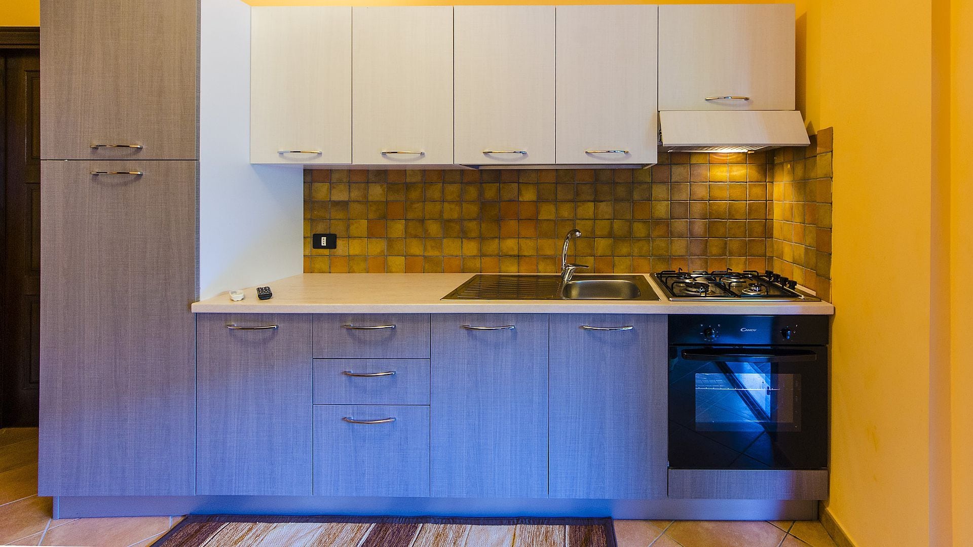 A compact kitchen with a gas stove, sink, and dishwasher.