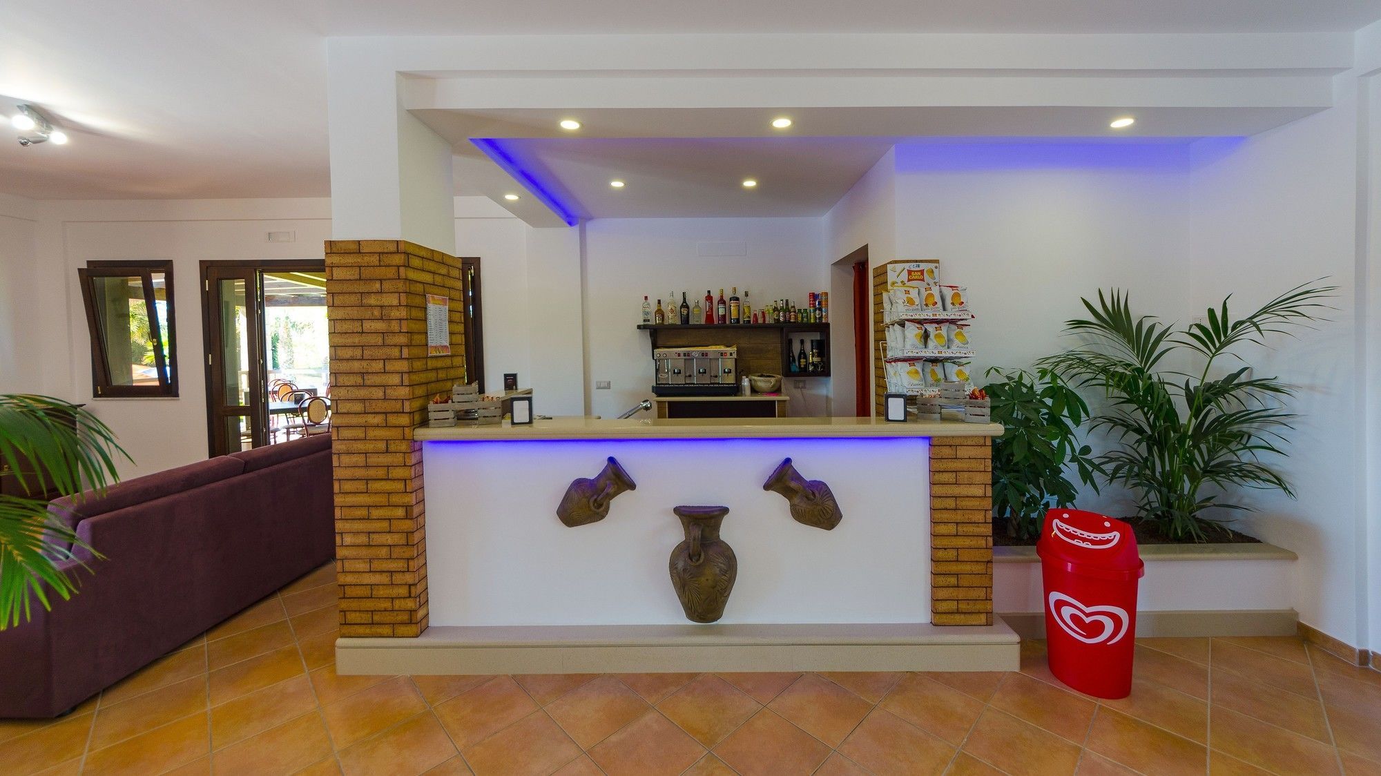A reception area with a counter, a coffee machine, and a shelf with various items.