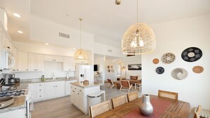 A spacious kitchen with white cabinetry, a central island, and pendant lighting. - Rancho Nopales JT-Pool, Hot Tub, Hammocks & Views (Joshua Tree)