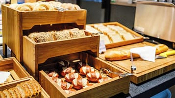 Ein Buffet mit verschiedenen Brotsorten und Gebäck in Holztabletts.