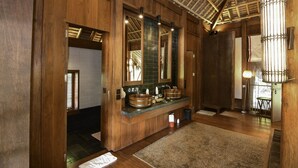 A wooden bathroom with a large mirror, two sinks, and a ceiling with exposed beams. - One Myanmar Resort Putao (Putao)