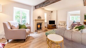 Una sala de estar acogedora con chimenea, asientos cómodos y ventanas amplias.