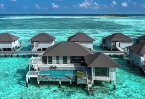 Cabañas sobre el agua con aguas azules cristalinas a su alrededor.