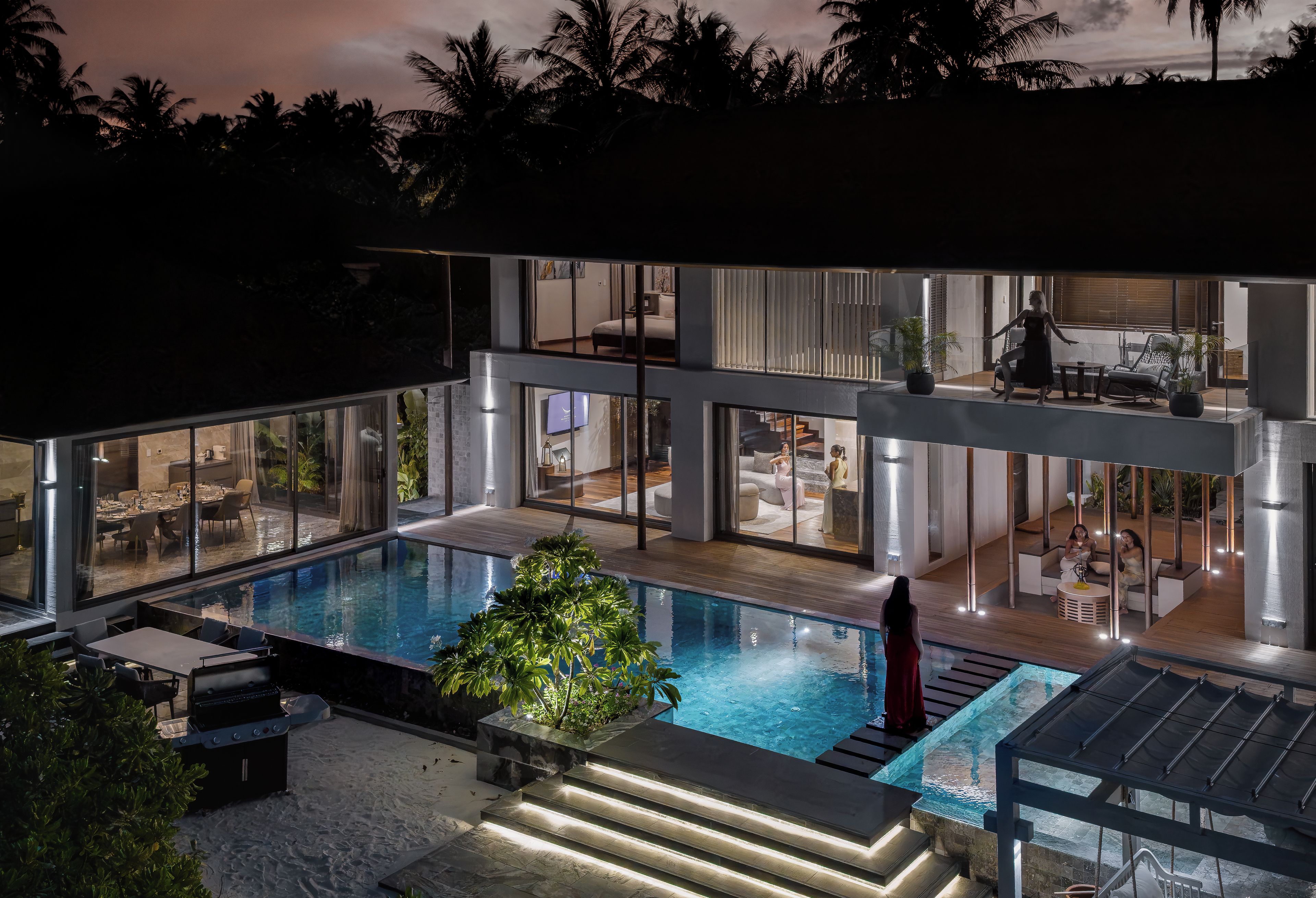 Ein modernes Haus mit Schwimmbad, Glasüren und einem Essbereich.