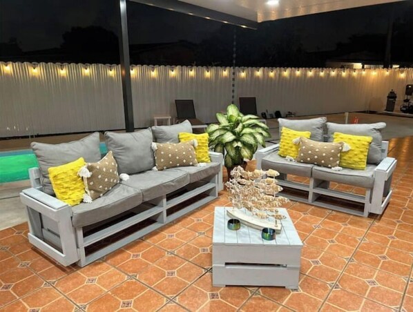 Relax in style with a comfortable sectional sofa and coffee table, set amidst a serene outdoor space.