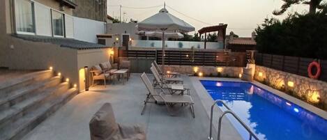 Una piscina al aire libre, tumbonas