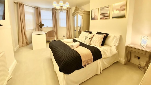 A bedroom with a bed, bedside table, and a desk with a chair.
