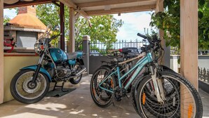 A covered outdoor area with a motorcycle and a bicycle. - Funtana Apartments Budinjaš APP 3 FREE BIKES (FUNTANA)