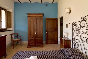 Ein Schlafzimmer mit Bett, Kleiderschrank, Stuhl und Schreibtisch.