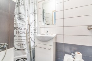 Tina con regadera, secadora de cabello, bidet, toallas 