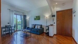 A spacious living area with a sofa, coffee table, and a dining table.