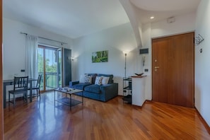 A spacious living area with a sofa, coffee table, and a dining table.