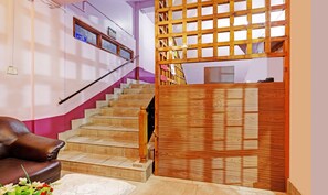 A staircase with wooden steps and a handrail, leading to a landing with a wooden partition.