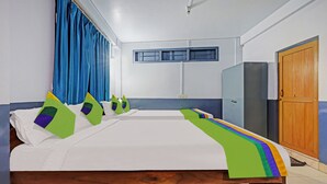 Een hotelkamer met een groot bed, een kledingkast, een deur en een raam.