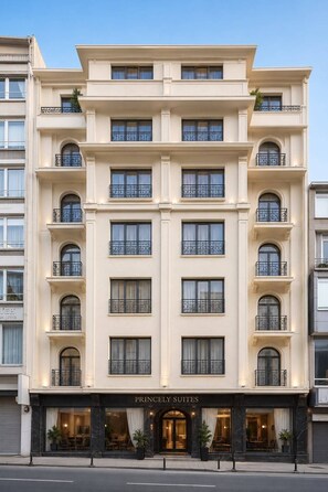 A multi-story hotel with a classic architectural style, featuring balconies with wrought iron railings and a ground-level entrance with a sign reading 'PRINCELY SUITES.' - Princely Suites (Istanbul)