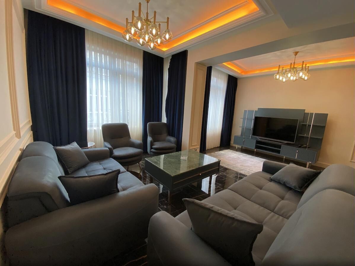 Un salon moderne comprenant un canapé, une table basse et un téléviseur à écran plat.